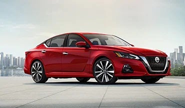 2023 Nissan Altima in red with city in background illustrating last year's 2022 model in All Star Nissan in Denham Springs LA